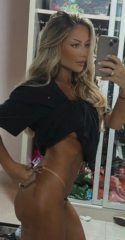 Cliente em selfie no espelho mostrando o bronze na barriga e no quadril.
